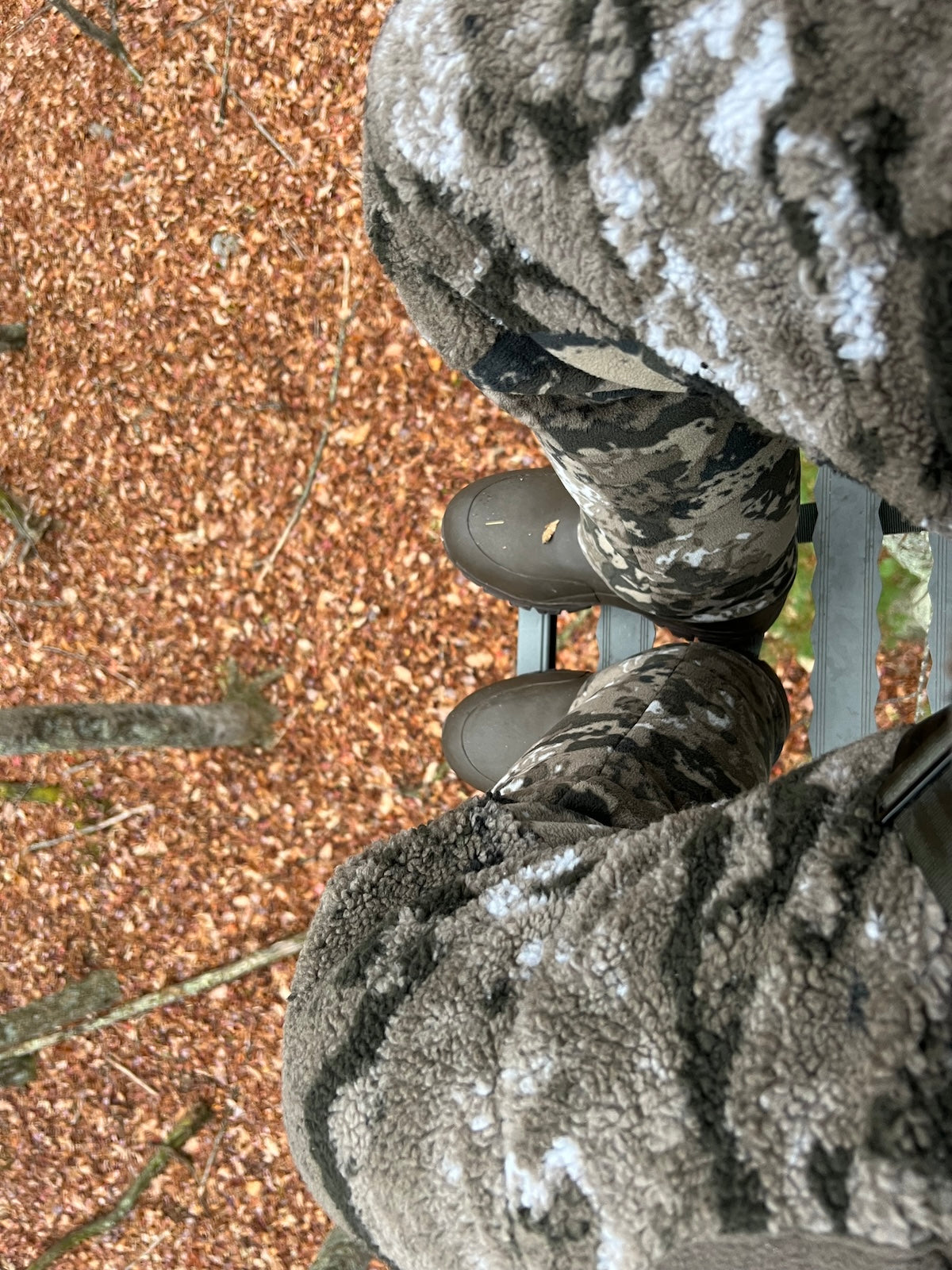Individual wearing camouflage pants , highlighting Pnuma's winter hunting apparel.
