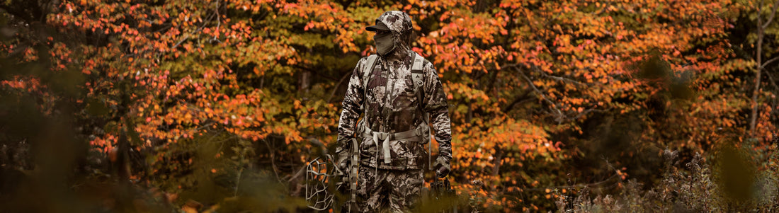 Camouflaged hunter moving through a wooded area