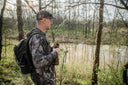 Hunter wearing Pnuma mild weather jacket and pants in a forest clearing during mid-season, prepared for changing temperatures and active spot-and-stalk pursuit.