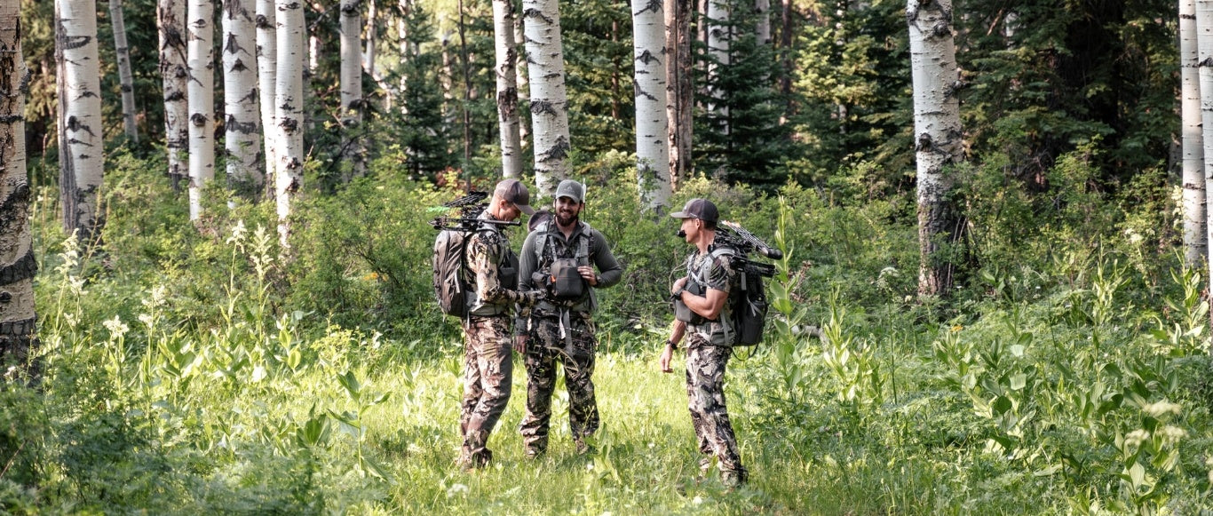 Three hunters wearing camouflage in the forest